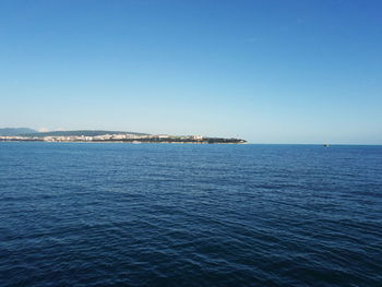 Sailboats sailing in sea against clear blue sky