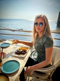 Portrait of young woman sitting at beach
