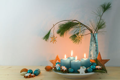 Close-up of christmas decorations on table against wall