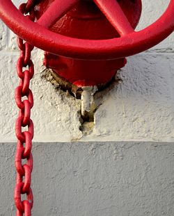 Close-up of red chain against wall