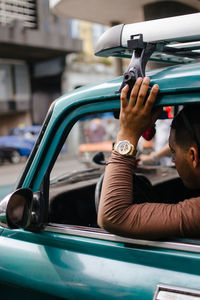 Close-up of hands on car in city