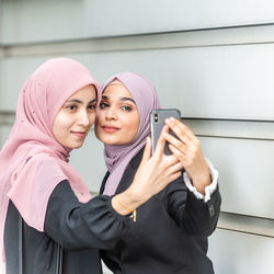 Portrait of a smiling young woman using mobile phone