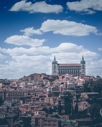 Buildings in city against cloudy sky