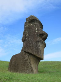 Low angle view of stone sculpture on field against sky