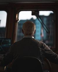 Rear view of man driving bus in city