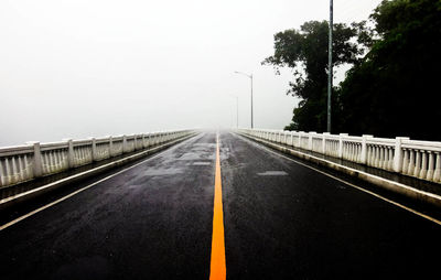 Empty road along trees