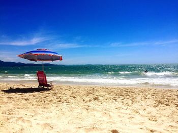 Lifeguard hut on beach against blue sky