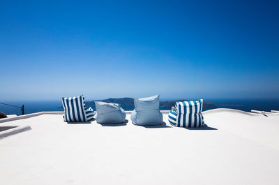 Seats on terrace against clear blue sky