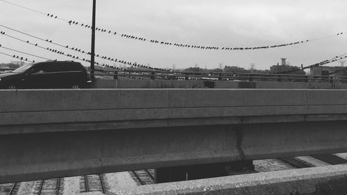 Cars on bridge in city against sky