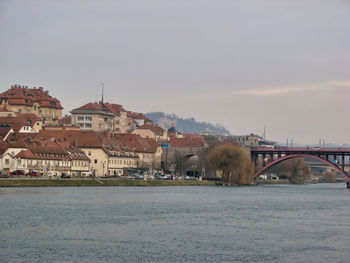 View of town by river against sky