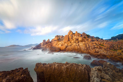 Scenic view of rocks in sea against sky