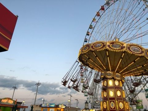 LOW ANGLE VIEW OF ILLUMINATED FERRIS WHEEL AGAINST SKY