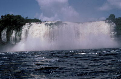 Scenic view of waterfall against sky