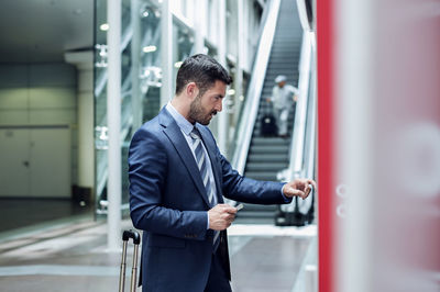 Businessman using atm in subway station