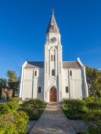 View of white dutch reformed church against blue sky, nieu-bethesda, south africa