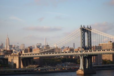 Manhattan bridge over east river in city against sky
