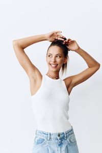 Portrait of young woman standing against white background