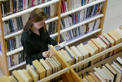 Close-up of young woman reading book in library