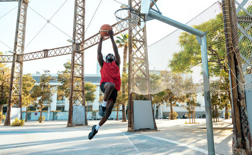 Low angle view of man jumping against trees