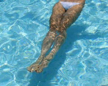 Low section of woman swimming in pool