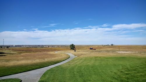 Scenic view of grassy field against sky