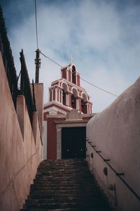 Low angle view of steps amidst buildings against sky