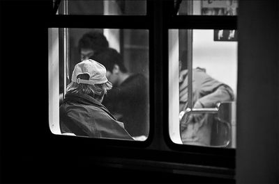 Man in subway train seen through window