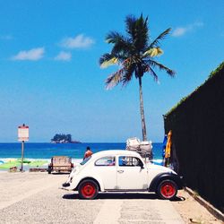 Vintage car parked at beach against sky