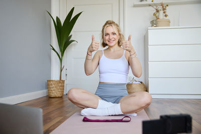 Young woman using mobile phone while sitting at home