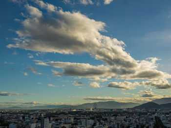 Aerial view of buildings in city against sky