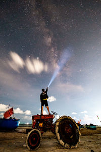 Man standing on field against sky at night