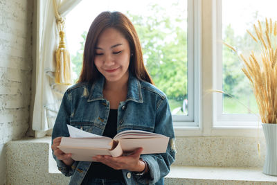 Portrait of young woman using mobile phone at home