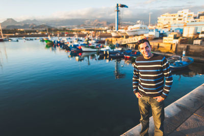 Portrait of smiling man standing against harbor