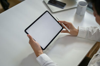 Cropped hands of woman using digital tablet