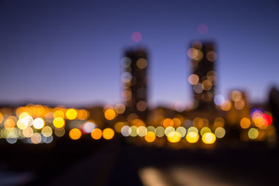 Defocused image of illuminated lights in city at night