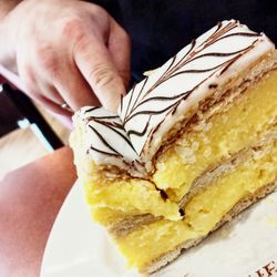 Close-up of hand holding cake slice in plate