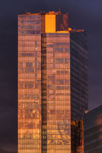 Modern office building against sky during sunset