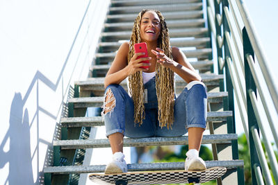 Low angle view of young woman sitting on staircase