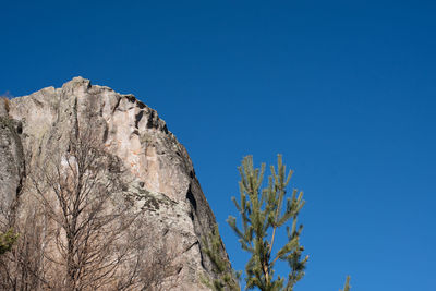 Low angle view of hill on clear blue sky