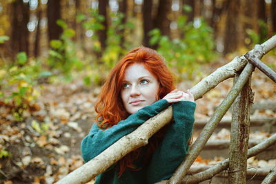 Portrait of woman with arms raised in forest