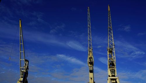 Low angle view of crane against blue sky