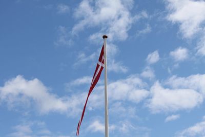 Low angle view of flag against blue sky