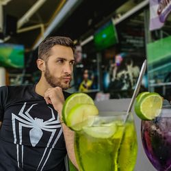 Close-up of drink with man in background sitting outdoors