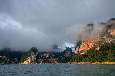 Scenic view of sea and mountains against sky