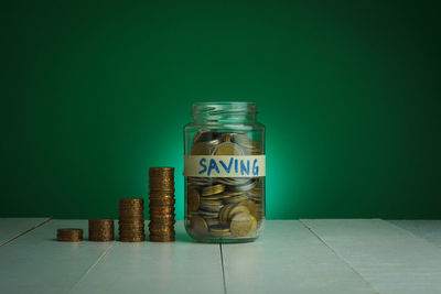 Close-up of coins in jar on table