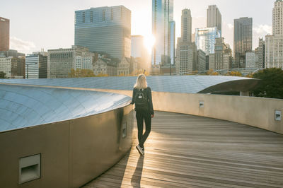 Rear view of woman on bp bridge against modern buildings in city