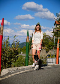 Portrait of young woman with dog on road