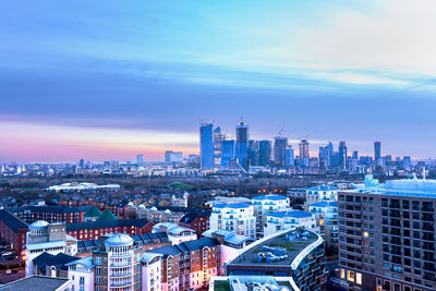 High angle view of city buildings against cloudy sky