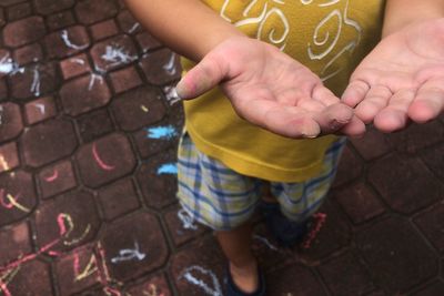 Low section of boy standing on footpath