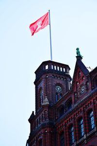 Low angle view of flag on building against sky